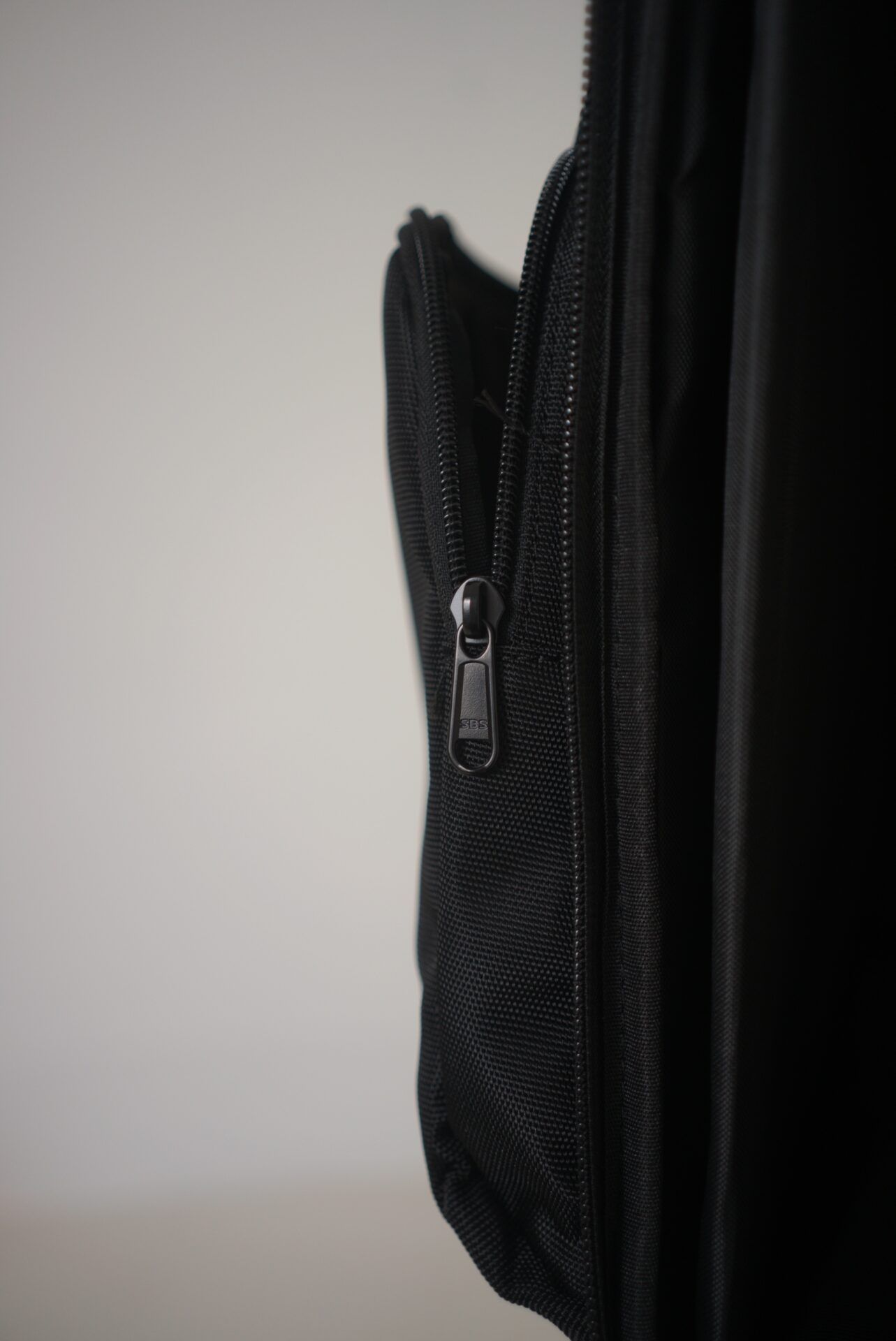 side view of the front pocket of the protect squared quad tcg backpack showing the zip